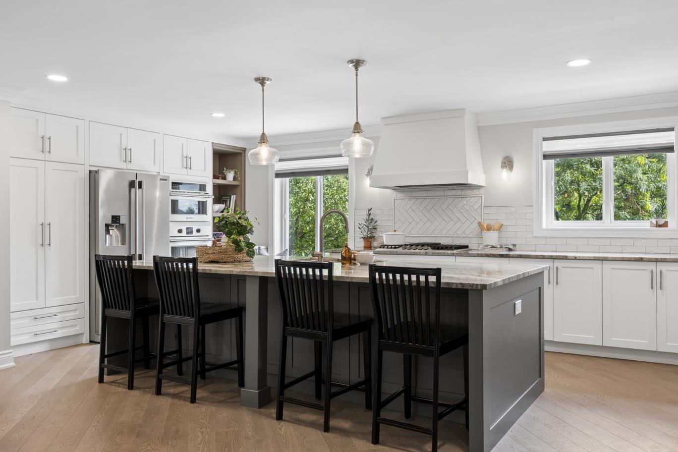 Kitchen island with pendant lighting overlooking backyard trees at 30 Potters Lane
