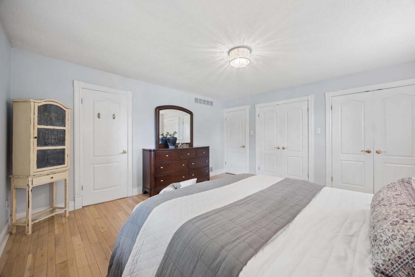 Primary bedroom with His and Hers closet doors at 30 Potters Lane